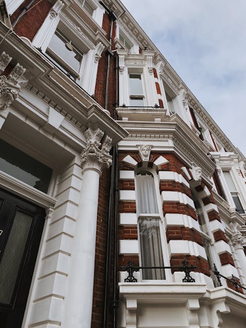 Photograph of a Victorian residential building with ornate architectural details, including decorative columns, intricate cornices, and alternating red brick and white stone facade. The building featu