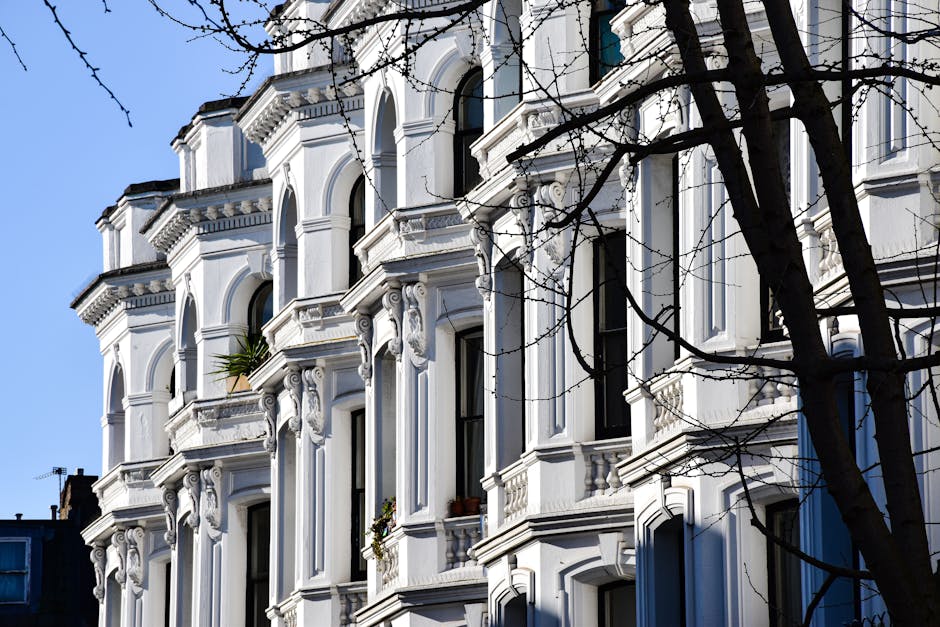 Photograph of a Victorian residential building with ornate architectural details, including decorative columns, intricate cornices, and alternating red brick and white stone facade. The building featu